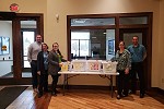 Waldo State Bank employees pose by laundry item donations for Safe Harbor.